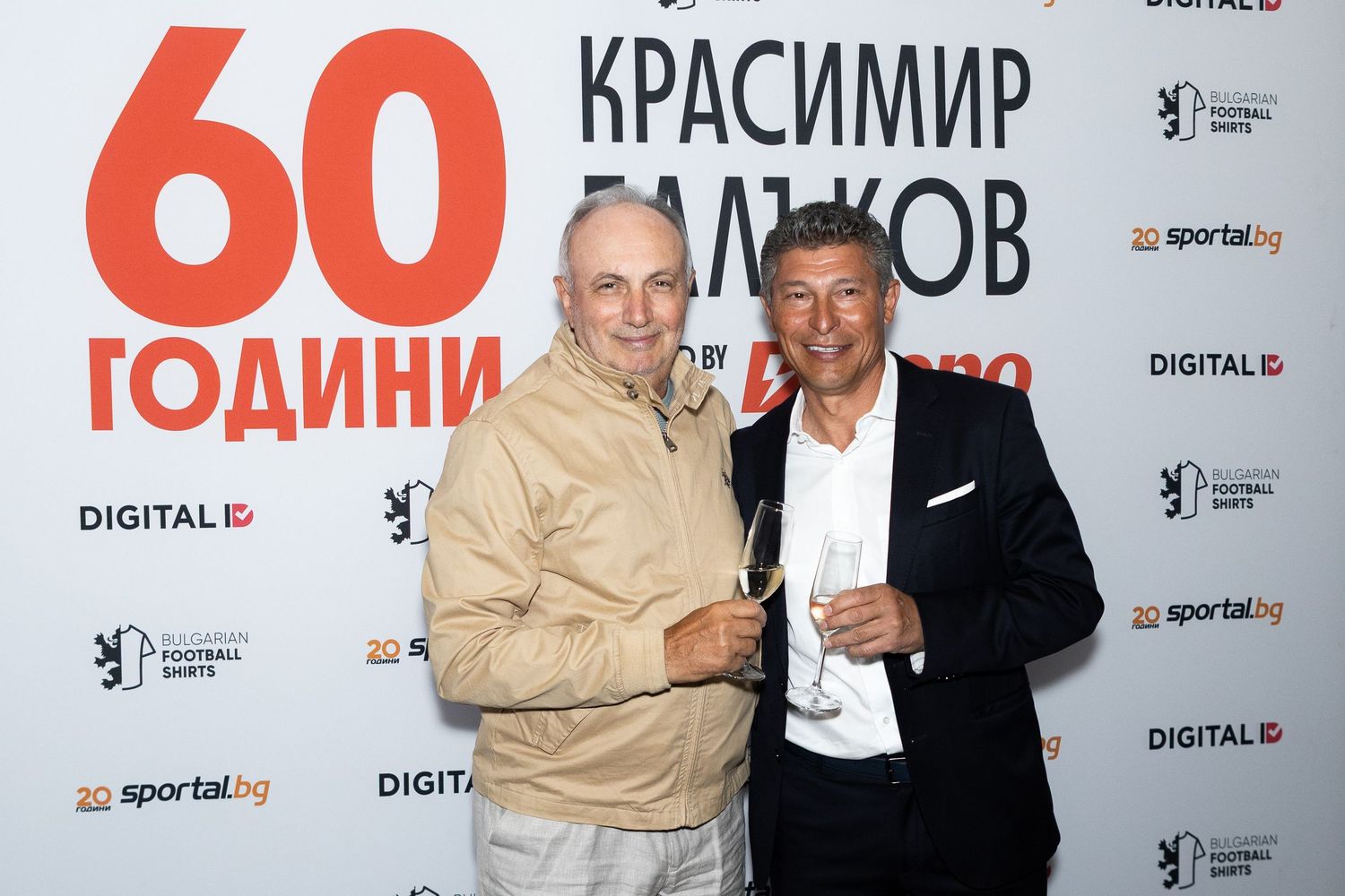 Two men toasting with champagne glasses at Krasimir Balakov's 60th birthday celebration event.