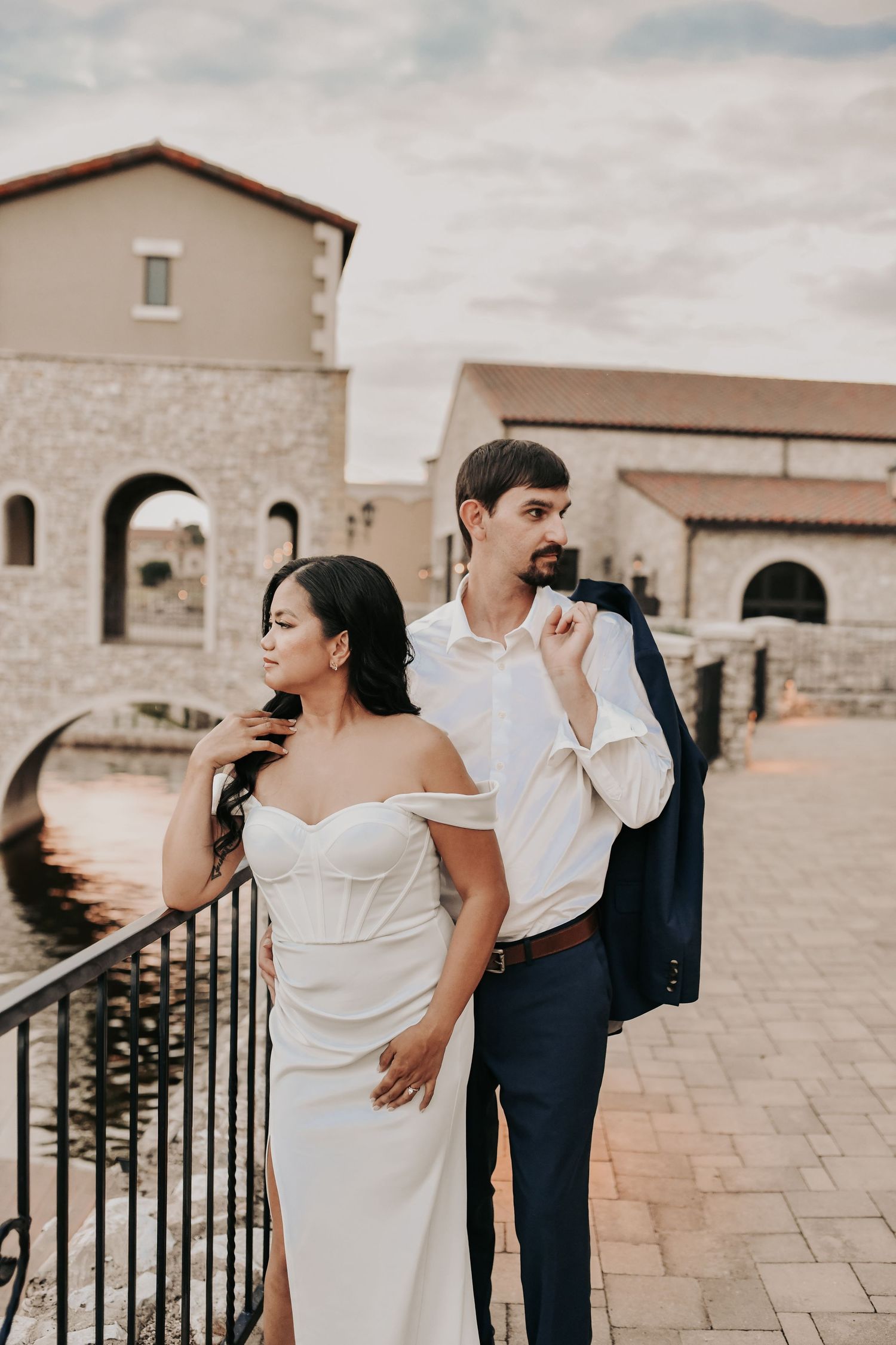Couple walking hand in hand along a stone terrace during their Chapel at Palacios engagement session