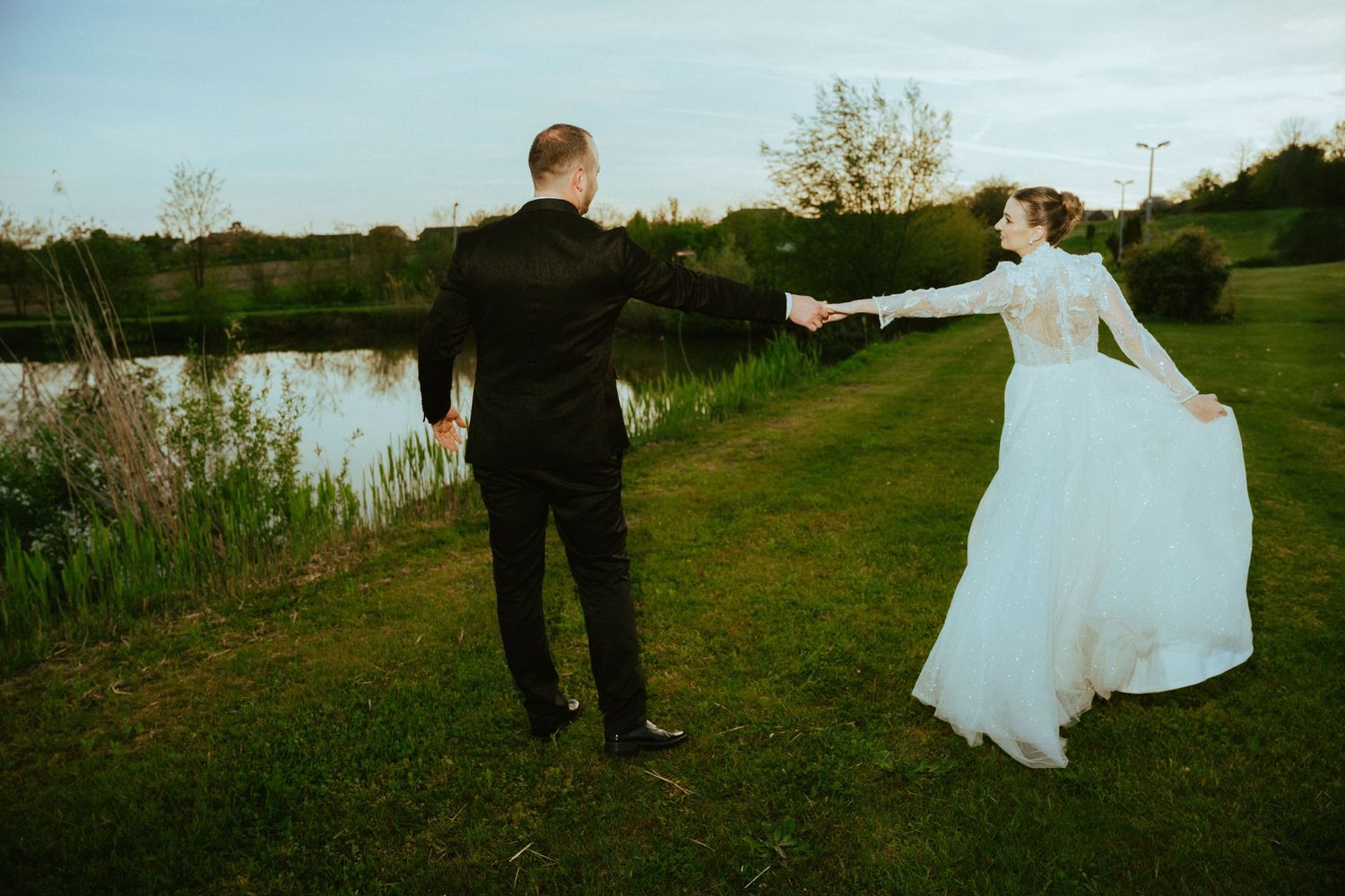 Elegant black and white portrait of newlyweds dancing together in a forest setting.