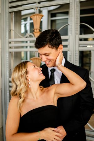 A romantic couple sharing intimate moments during an indoor formal photoshoot.