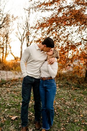 Intimate couple portraits captured in warm autumn light with falling leaves.