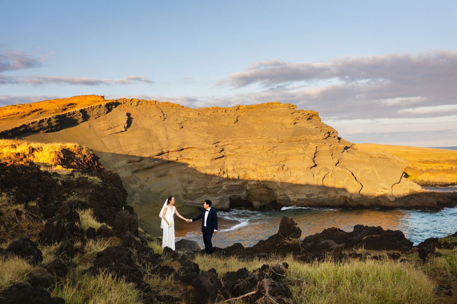 Couple dances at snowy Delicate Arch in Arches National Park, woman wearing vibrant yellow skirt.