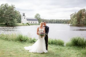 A collection of romantic wedding photos taken outdoors by a serene lakeside with a white church in the background.