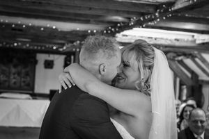 A black and white wedding sequence shows a couple sharing their first dance under twinkling lights at a reception.