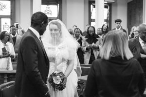 A collage of black and white wedding photos showing ceremony and reception moments at an indoor venue.