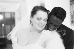 Black and white wedding photo showing couple having intimate moment during first dance at reception.