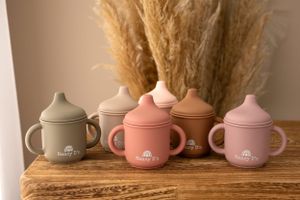 A collection of pink and gray ceramic teapots displayed in a row.