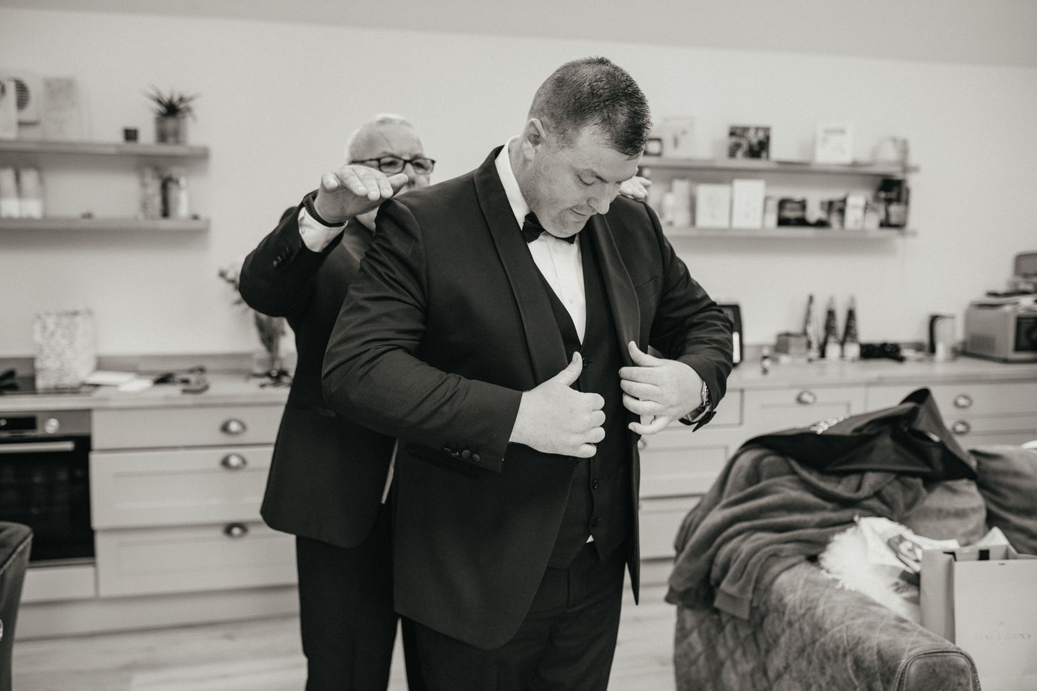 Pre-wedding preparations in black and white as people get ready indoors.