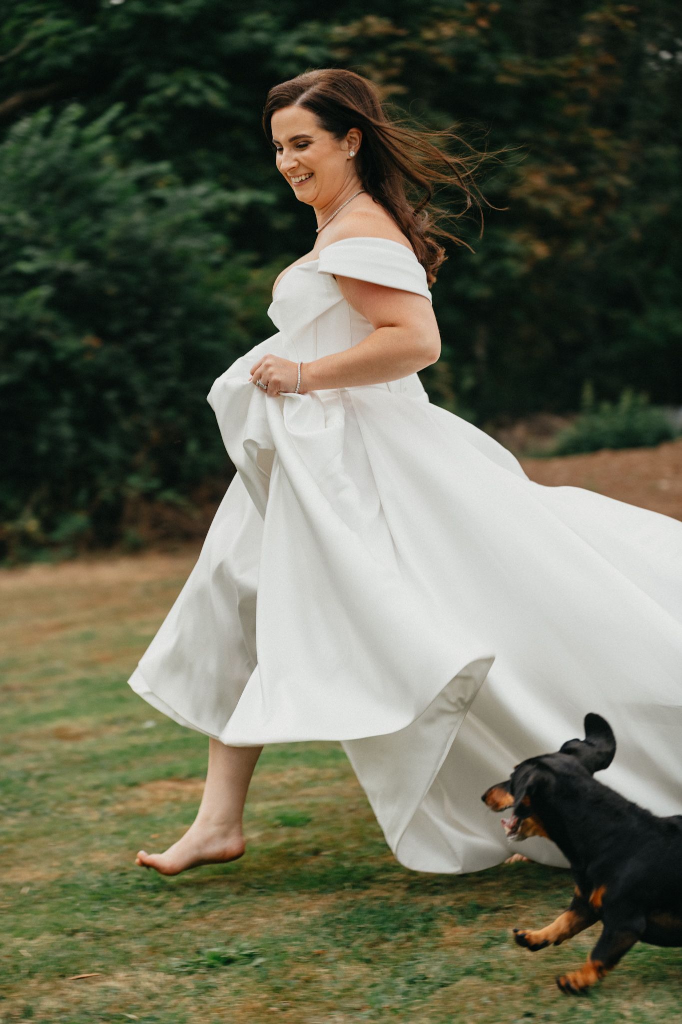 White wedding dress flowing in motion during an outdoor photo session with a dog.