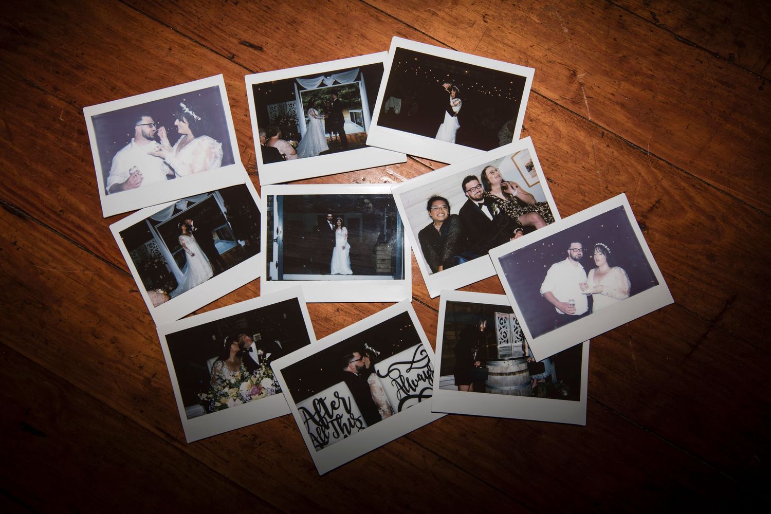 Black and white vintage photographs scattered on dark wooden table creating nostalgic atmosphere.