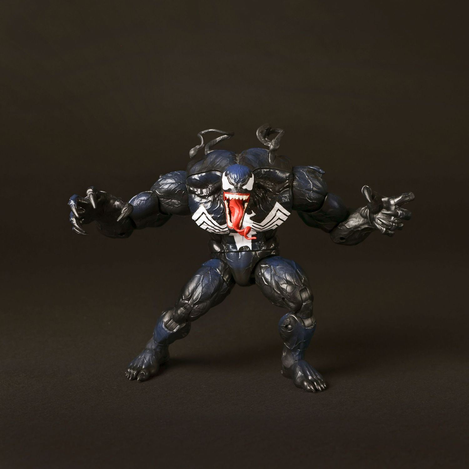 Action figure of a robotic panther displayed in different crouching and leaping poses against a dark background.