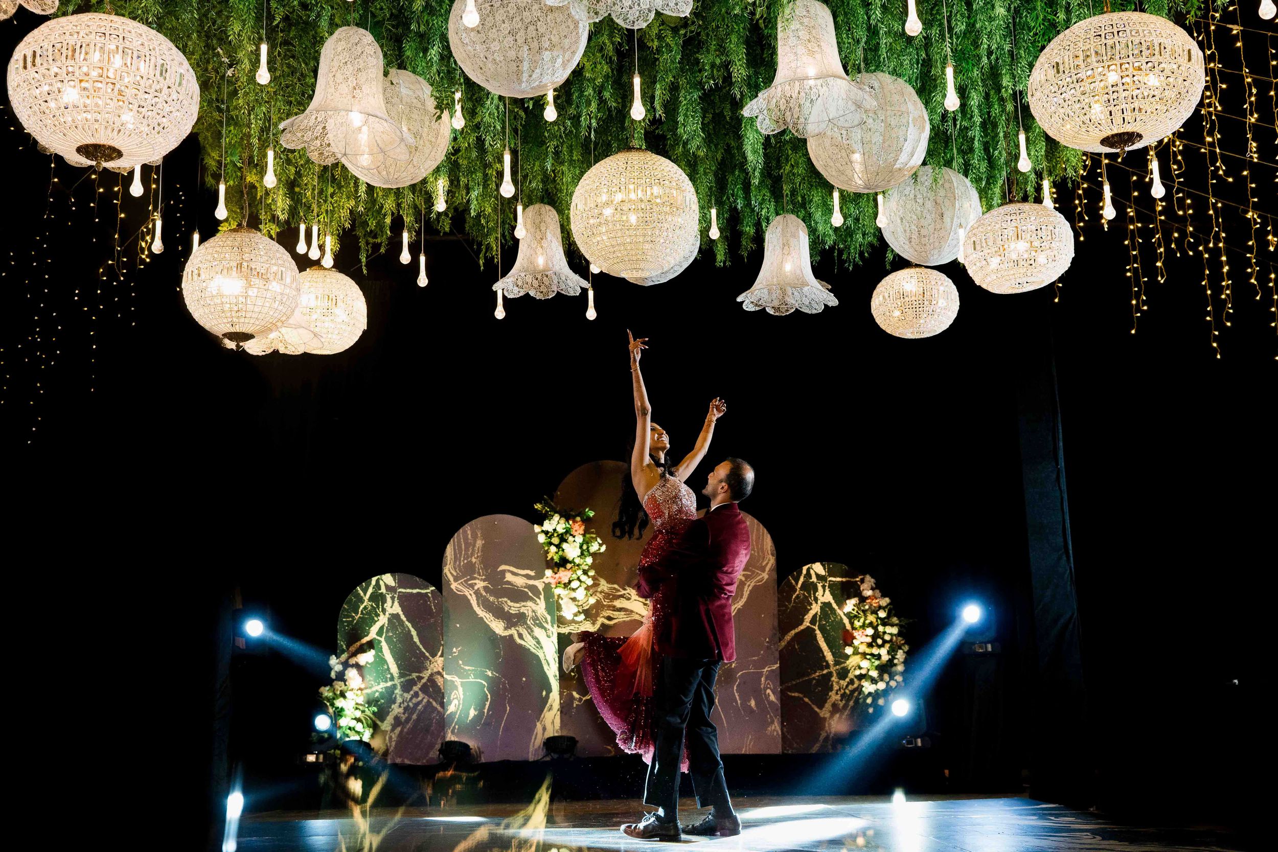 Paper lanterns illuminate a dance performance with dramatic lighting and artistic movement on stage.
