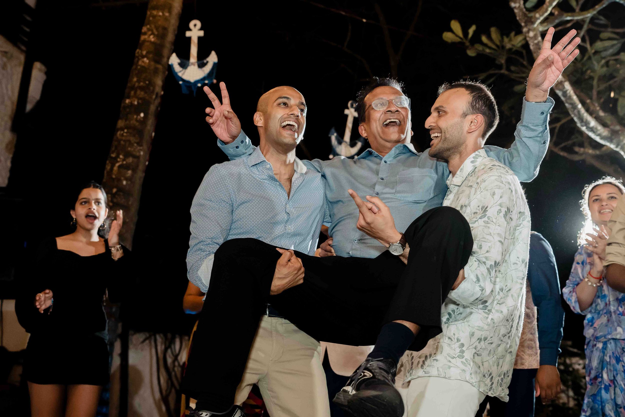 Wedding guests dance and celebrate on a crowded dance floor during evening reception festivities.