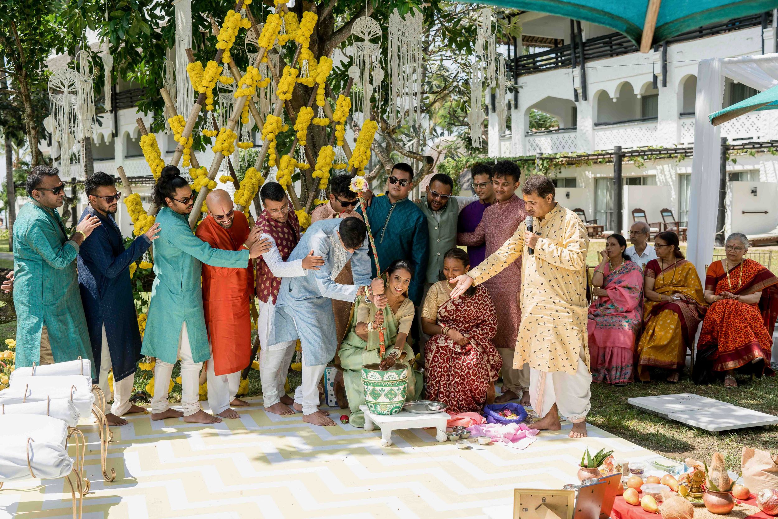 A festive Indian wedding celebration with guests in traditional attire dancing and celebrating at an outdoor venue.