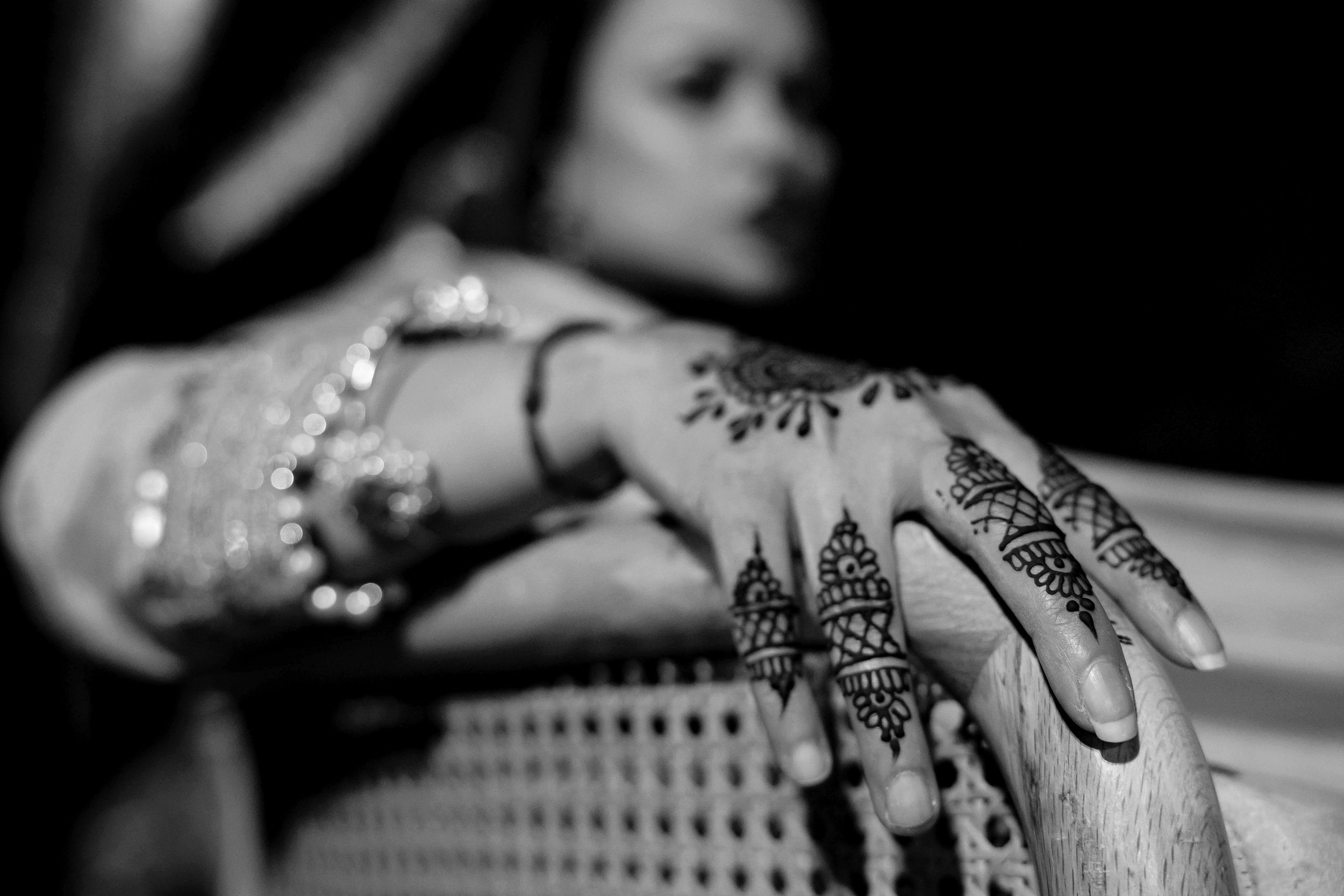 Intricate henna designs adorning hands for wedding mehndi ceremony feature delicate floral and geometric patterns.