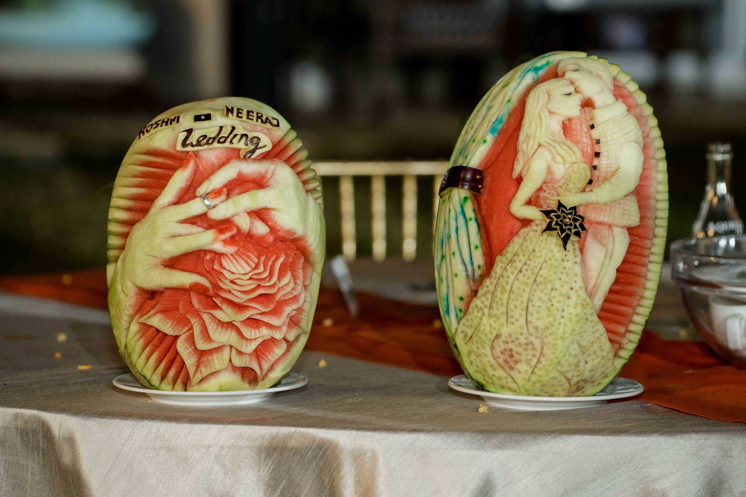 Creative watermelon carvings featuring red dragon designs displayed in a row on a table.