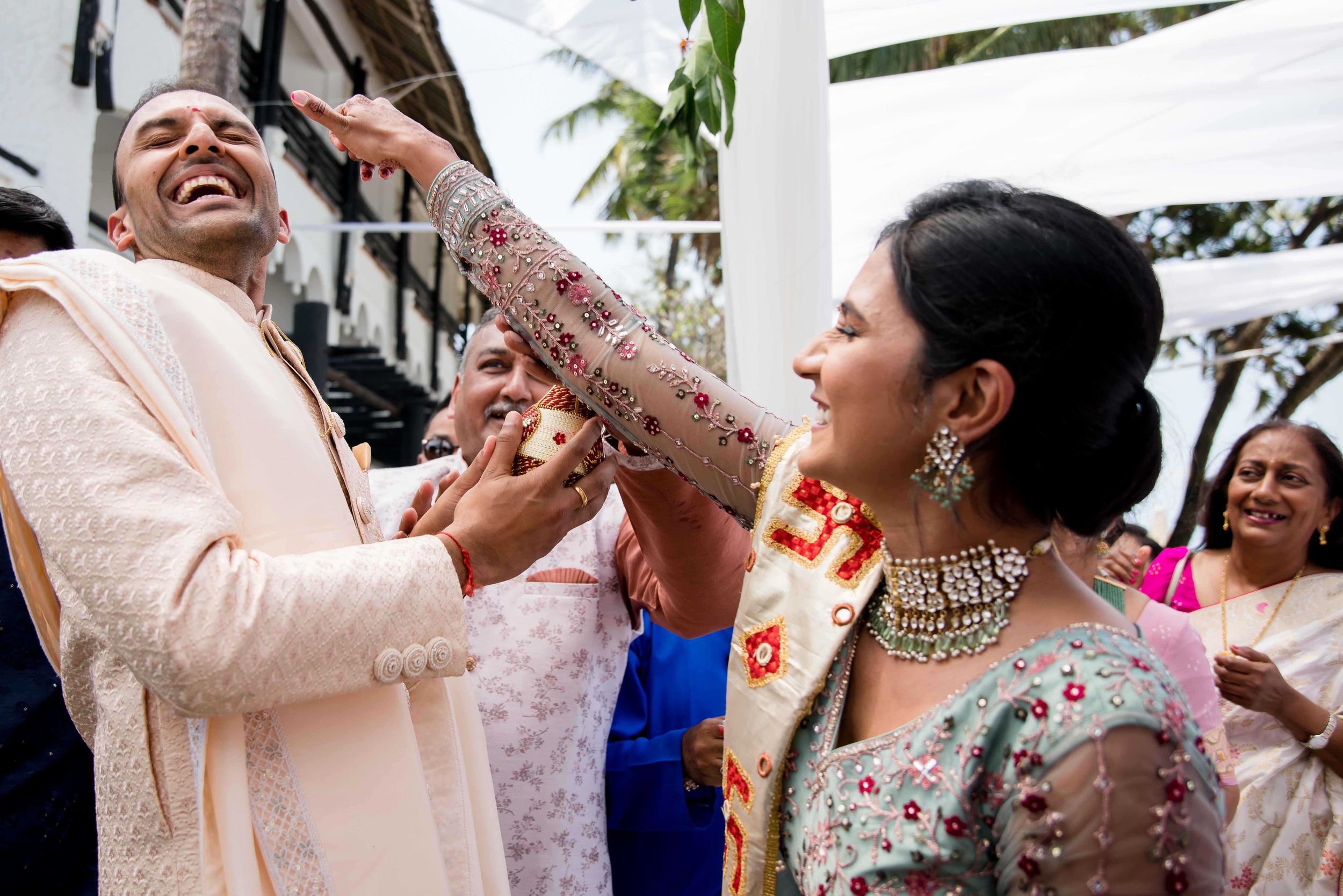 A joyful celebration scene with people dancing and smiling at what appears to be a wedding or festive gathering.