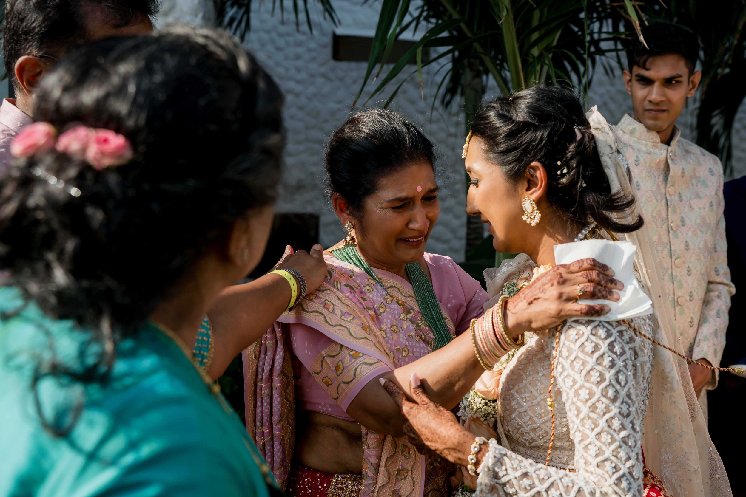 Guests at a traditional South Asian wedding celebration share an emotional moment during the ceremony.