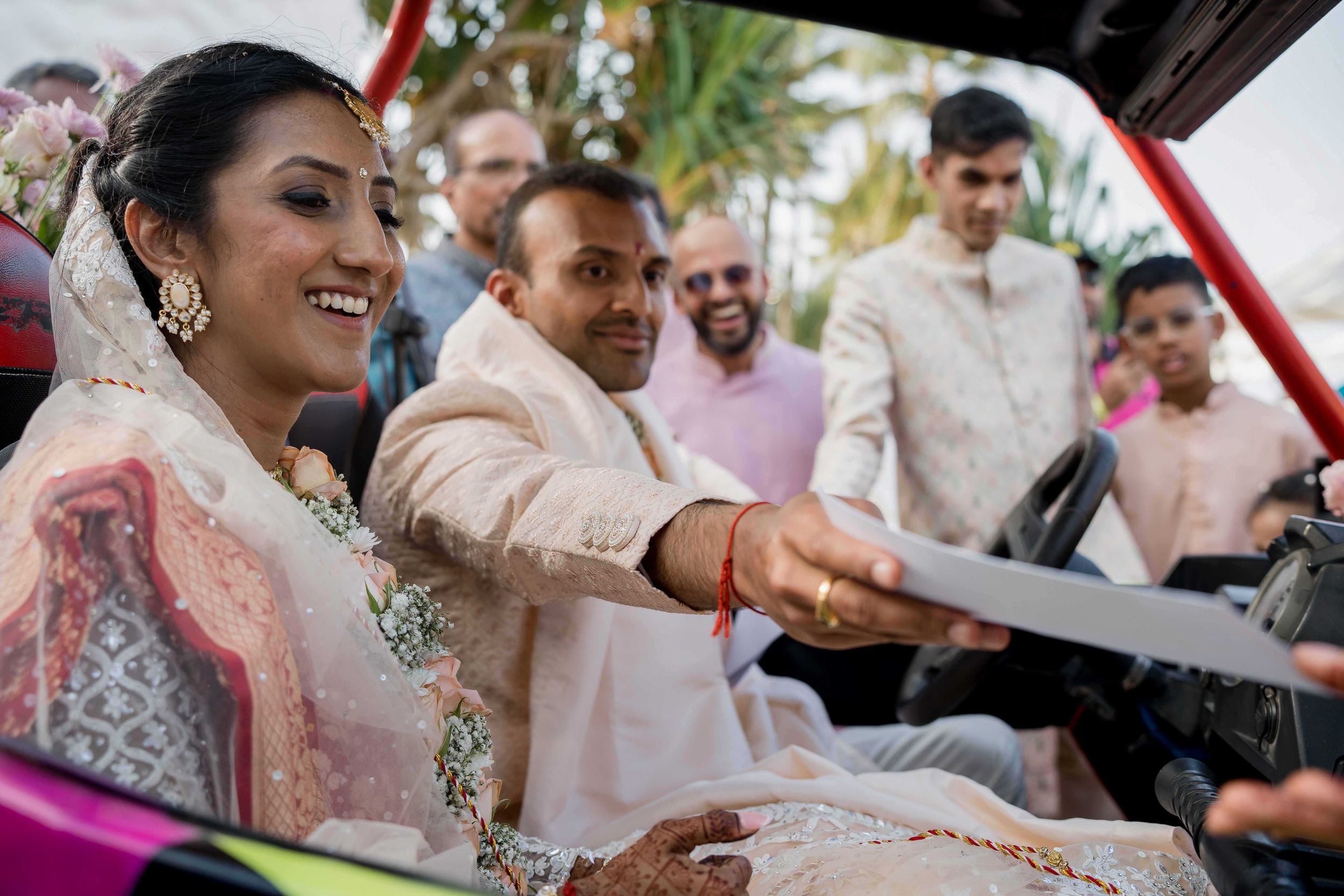 Wedding guests in traditional Indian attire interact during a festive celebration ceremony.