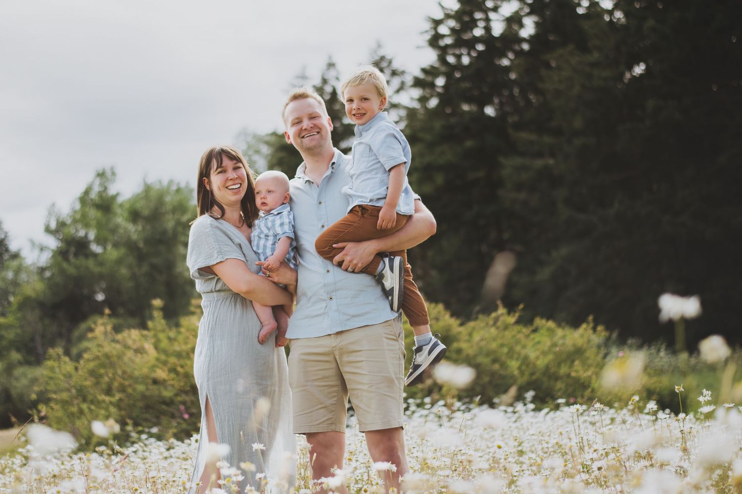 Family enjoying a summer day together in a blooming wildflower field during photography session.