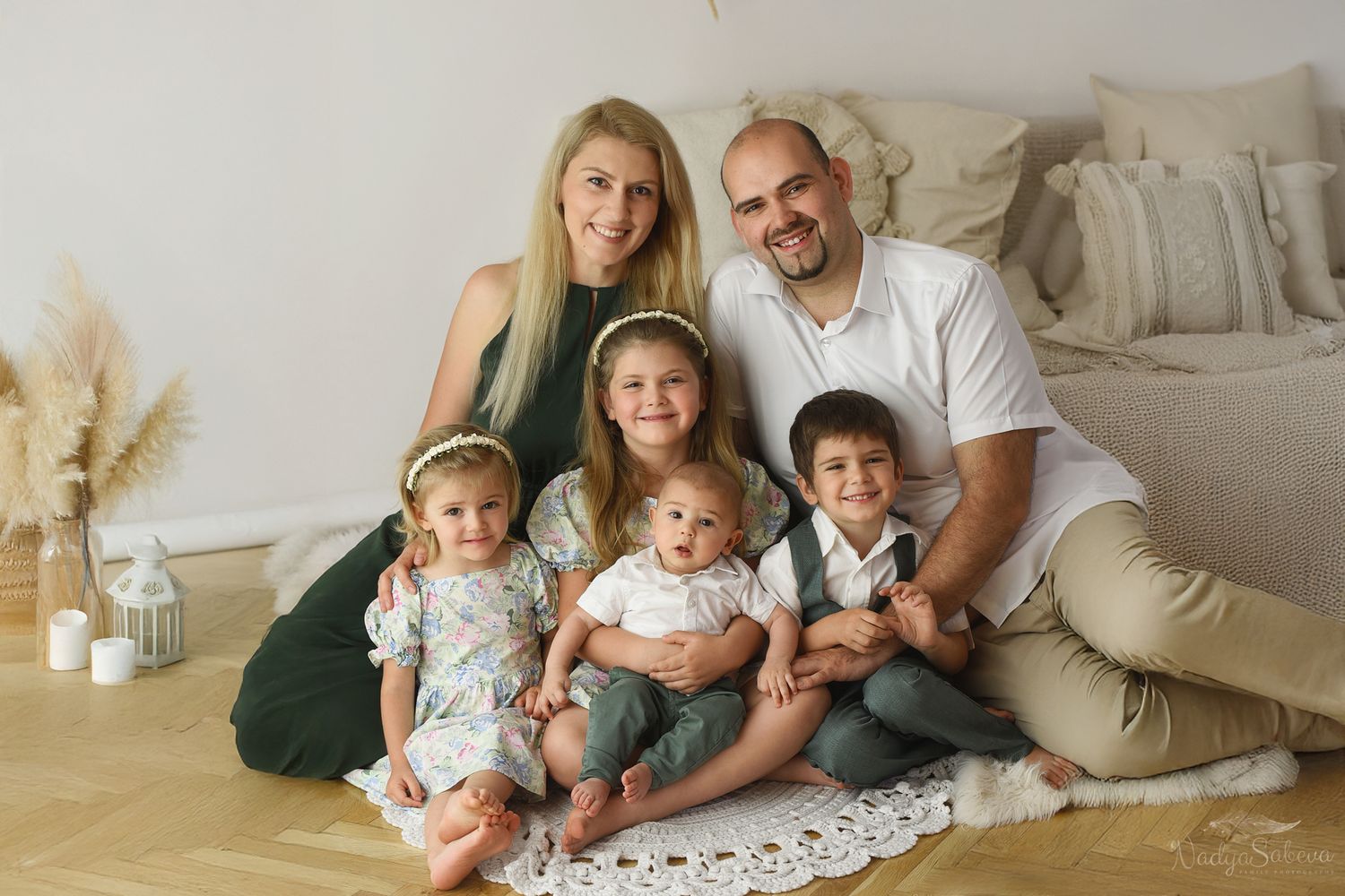 Family portrait outdoors in a garden setting with natural greenery background in autumn.