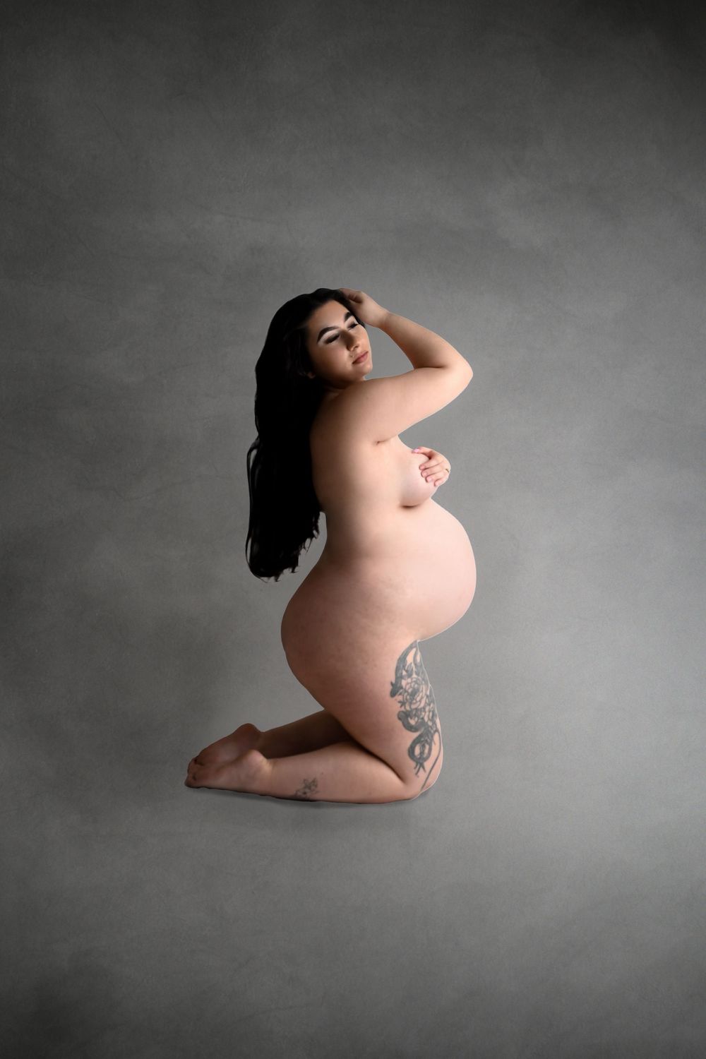 Minimalist maternity art photo on grey background showing natural form.