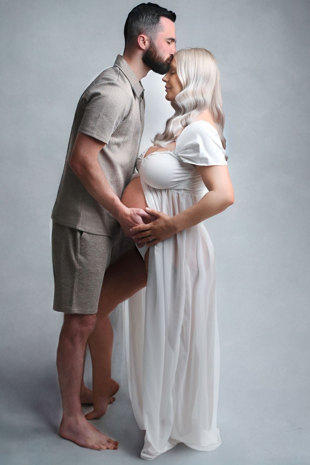 Intimate couple's maternity photoshoot with partner wearing beige shorts and expecting parent in white dress.