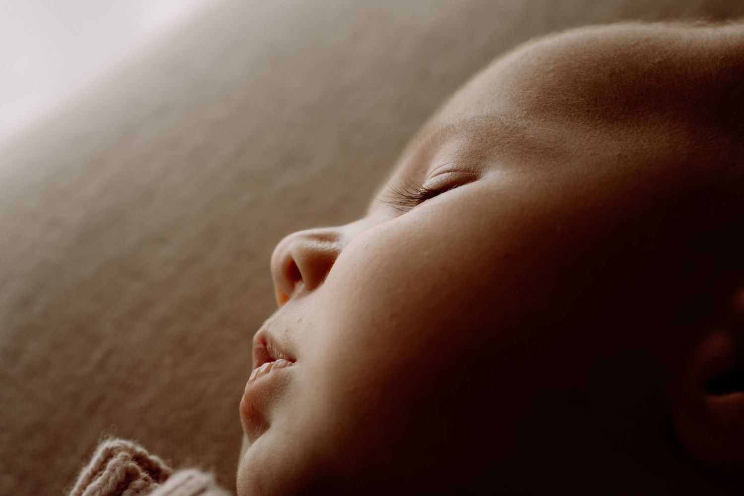 Intimate close-up portrait in soft natural lighting showing gentle curves and shadows.