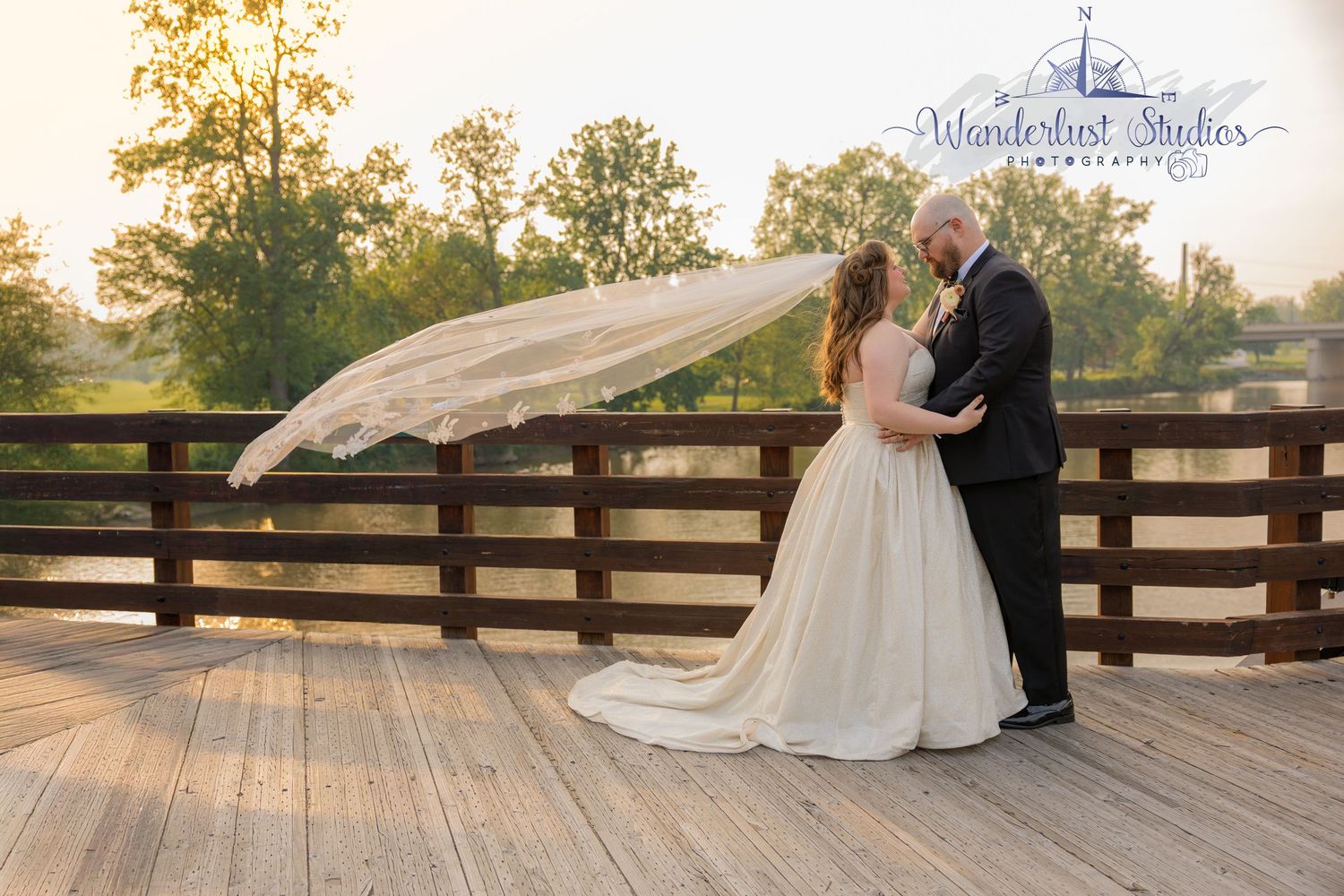Bride and Groom in Midtown Michigan, on the Thridge, with her veil sweeping in the wind, taken by Wanderlust Studios