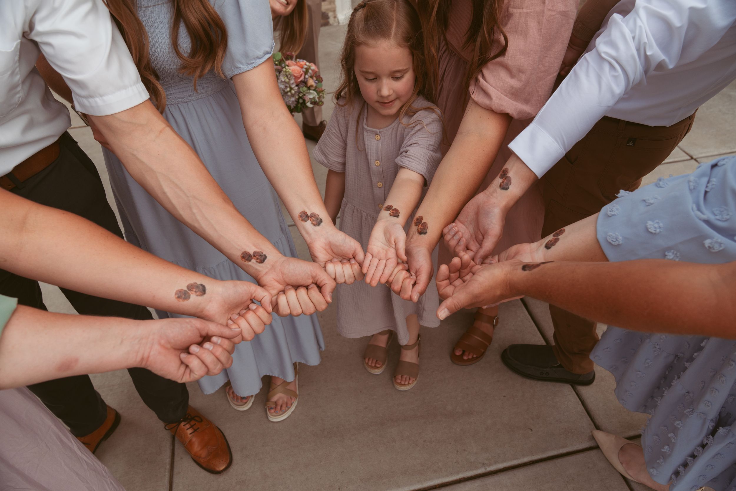 A group photo showing hands stacked together in a team unity gesture at an event.