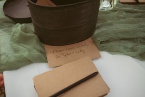 Handmade leather wallet crafted in shades of brown sits on white paper with handwritten notes in background.