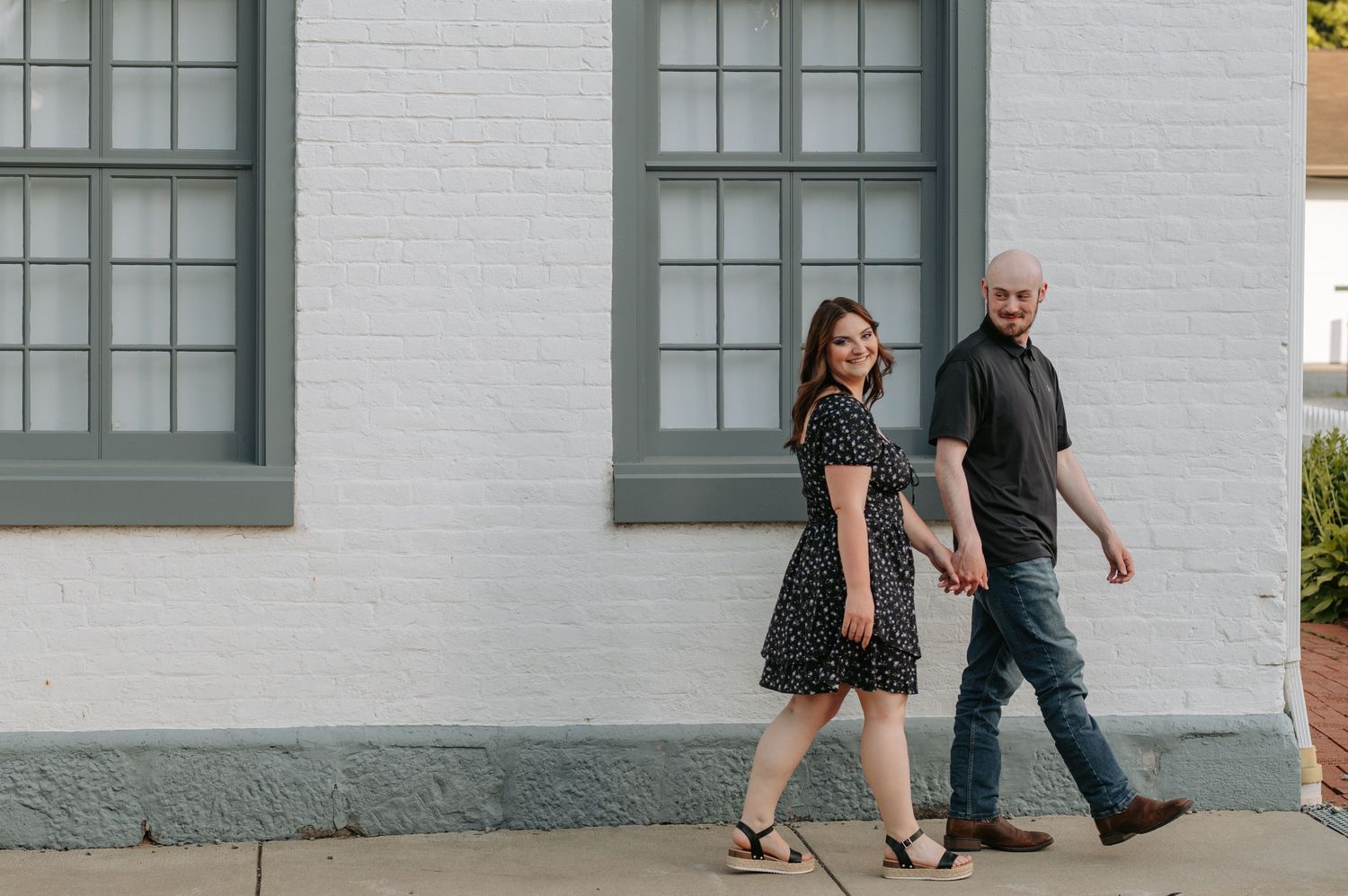 A blurry image of a couple holding hands as they walk through a grassy area.