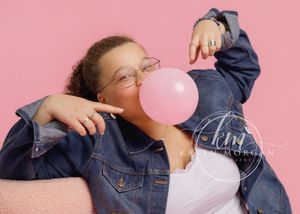 Person in denim jacket holding pink balloon against pink background in sequence of four connected photos.
