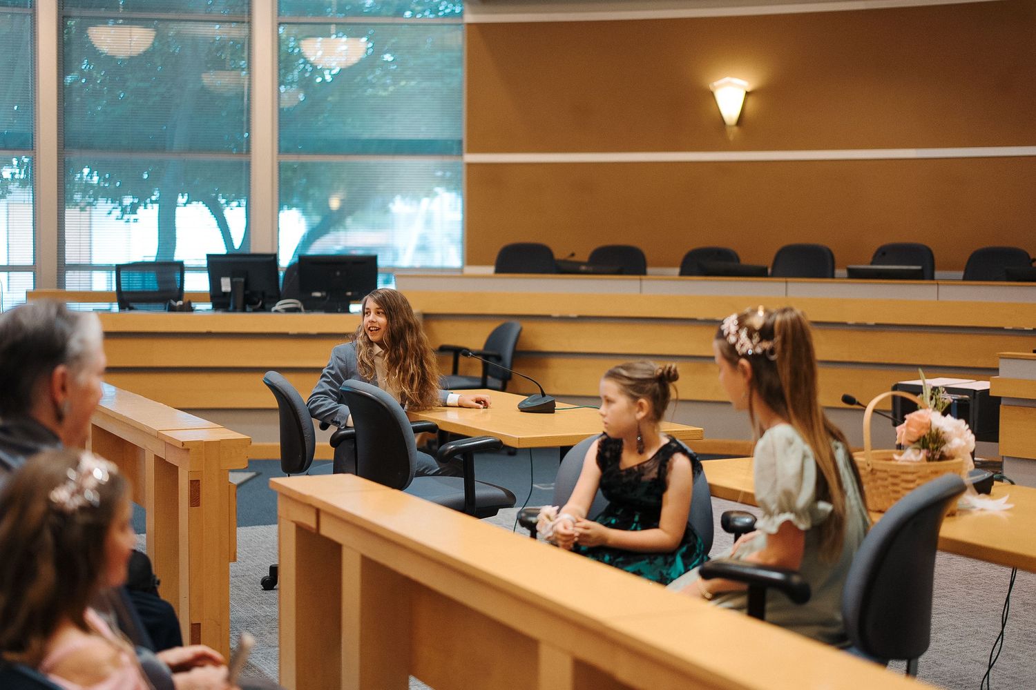 People collaborate in a modern classroom setting with wooden desks and pendant lighting fixtures.