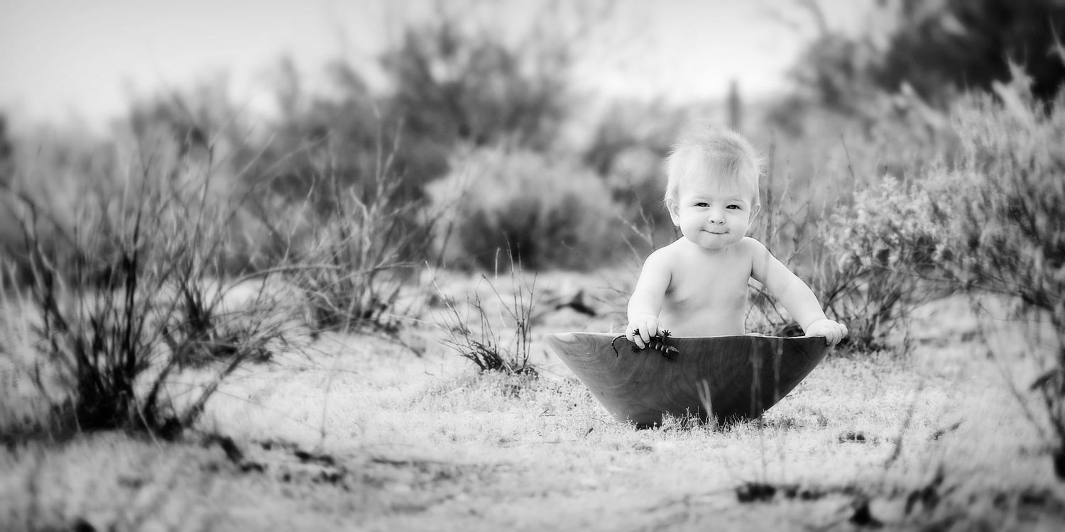 black and white image of a baby in a tub