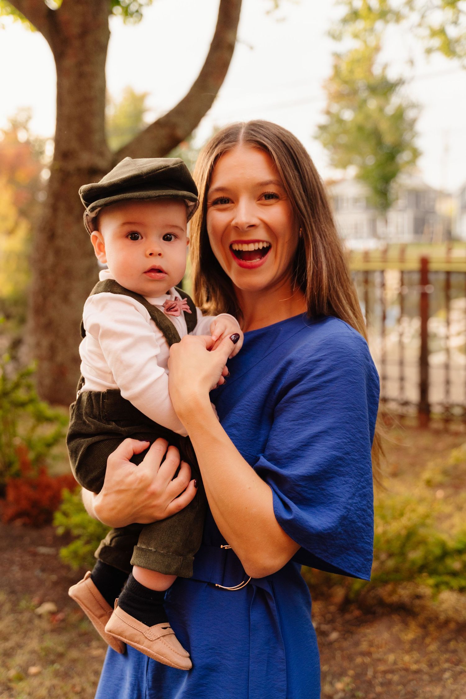 Joyful outdoor portrait with small child wearing newsboy cap and formal attire.