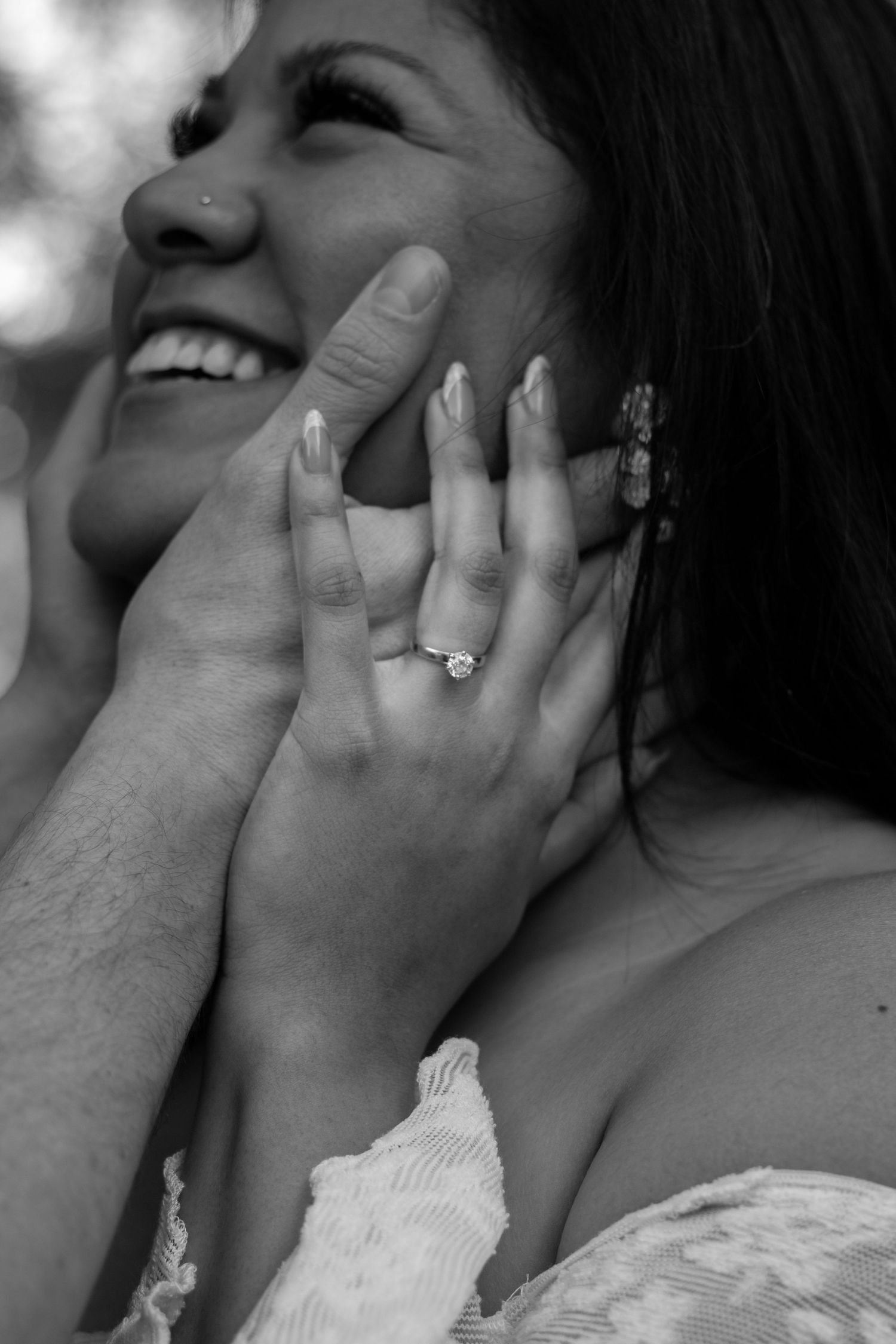 Joyful couple laughing and holding hands in a sunlit field, capturing their love and excitement for the journey ahead.