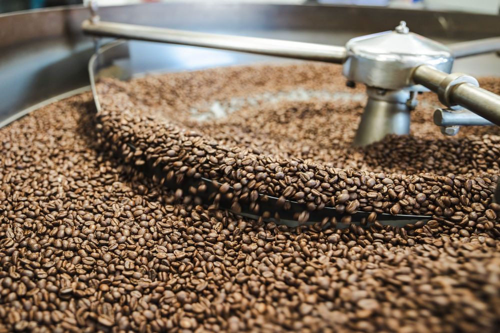 A time-lapse sequence showing freshly roasted coffee beans cooling in a commercial roasting machine.