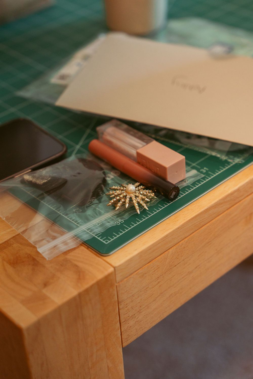 Wedding accessories and planning materials on green cutting mat surface.