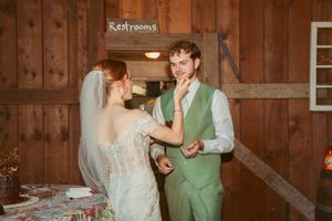 A wedding couple sharing a moment in a rustic wooden barn interior.