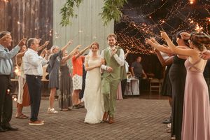 Wedding party celebrating as sparklers illuminate the evening at an outdoor venue.