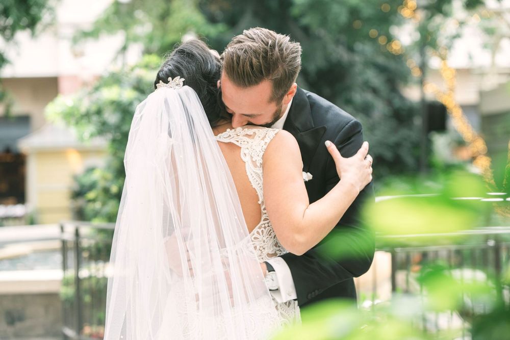 A romantic wedding couple shares tender moments in a lush garden setting during their special day.