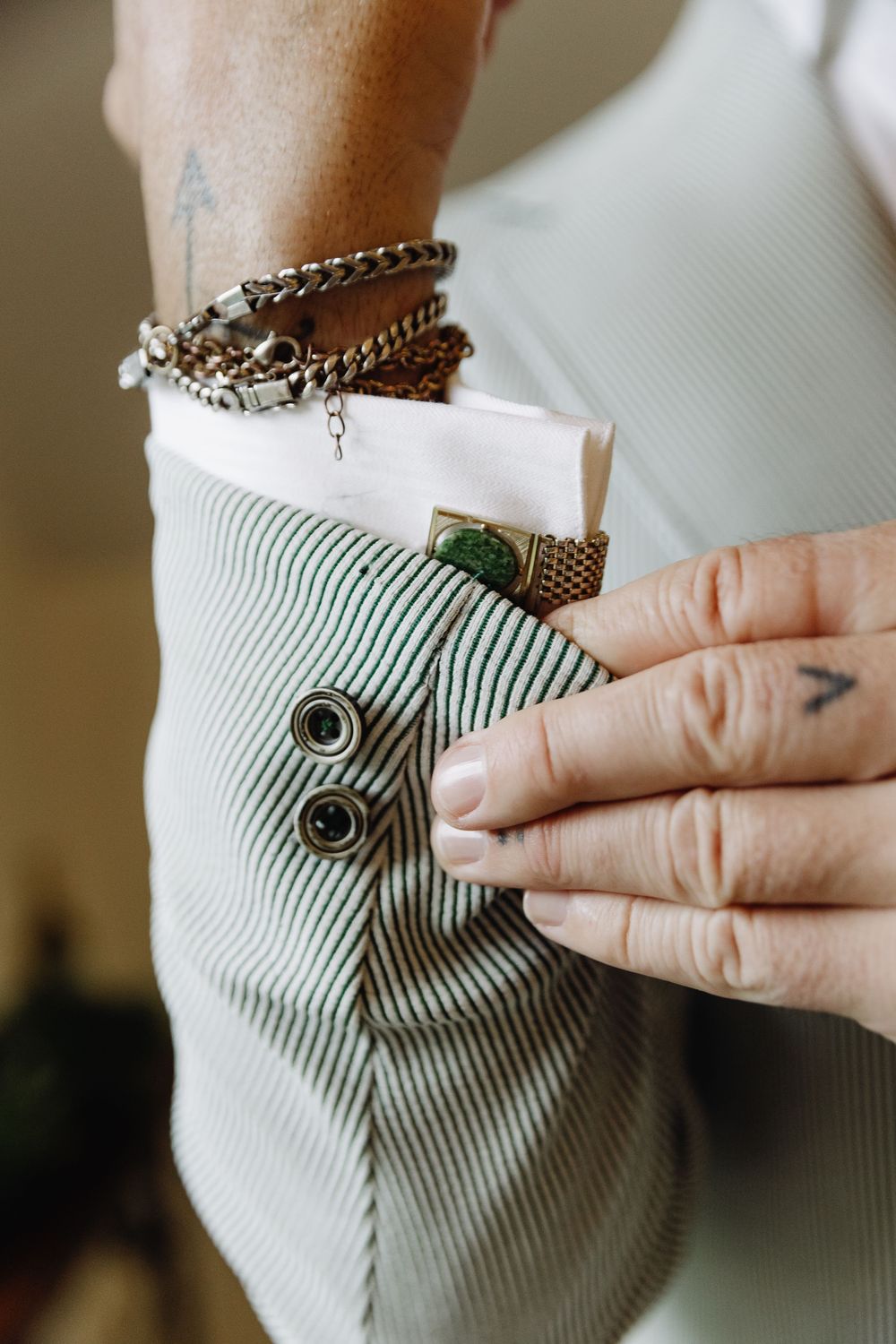 Close-up sequence showing hands fastening a small metal button closure on a light blue ribbed fabric.