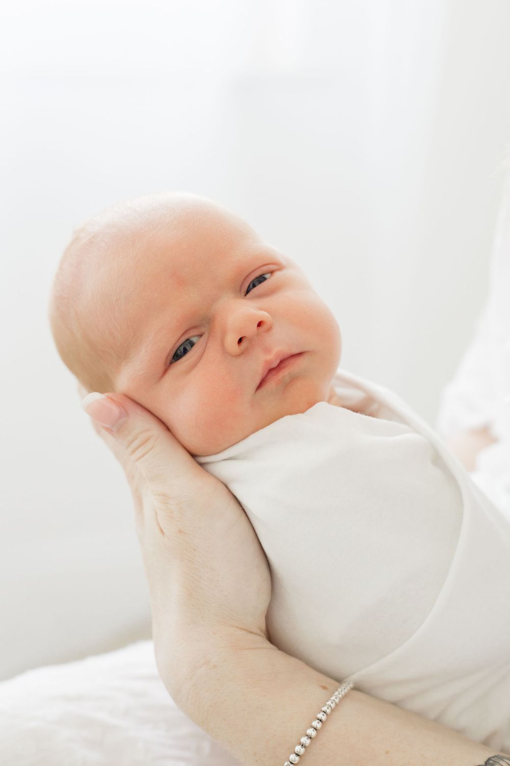 Close up portrait series of newborn baby in white clothing against bright background.
Newborn, Maternity & Family Photographer in Brighton