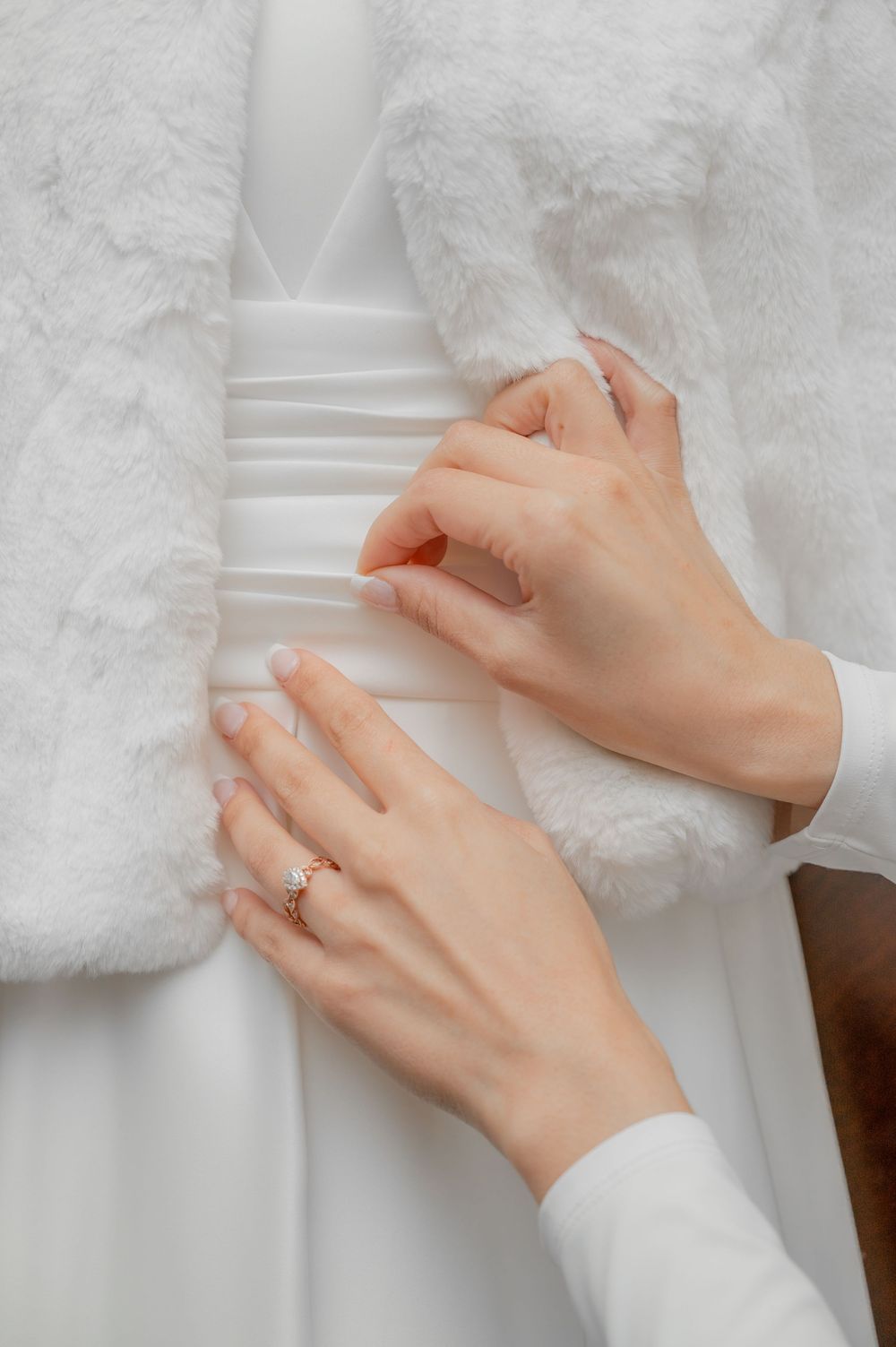 Close-up of hands adjusting white lace fabric details.