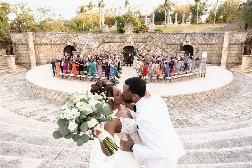 Wedding ceremony taking place in a beautiful stone amphitheater with guests seated in a semicircle arrangement.