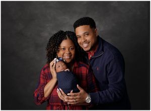 Family portrait with parents and young child holding newborn in Austin photography studio