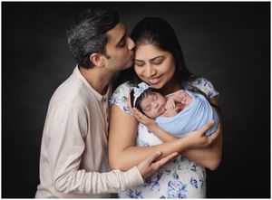 Parents holding their newborn baby during studio family portrait session in Austin newborn photography studio