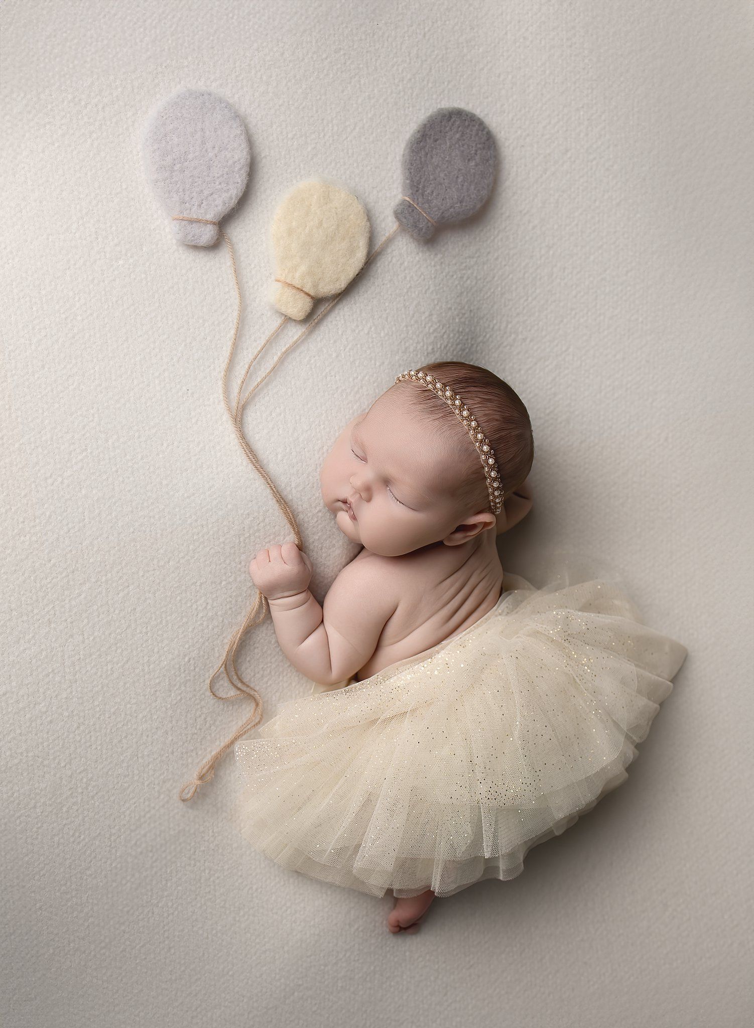 Newborn baby posed with neutral balloon prop during studio newborn session in North Austin