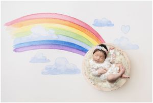 Artistic newborn portrait with rainbow watercolor backdrop created in Austin newborn photography studio